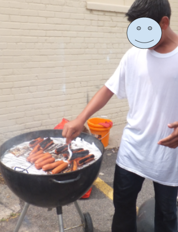 A student grilling hot dogs, which were sold at a student-led car wash.
