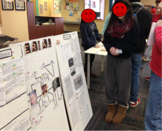 A photo of a student standing in front of her project she made for Serial at an exhibition night. Her project was a massive concept map. 